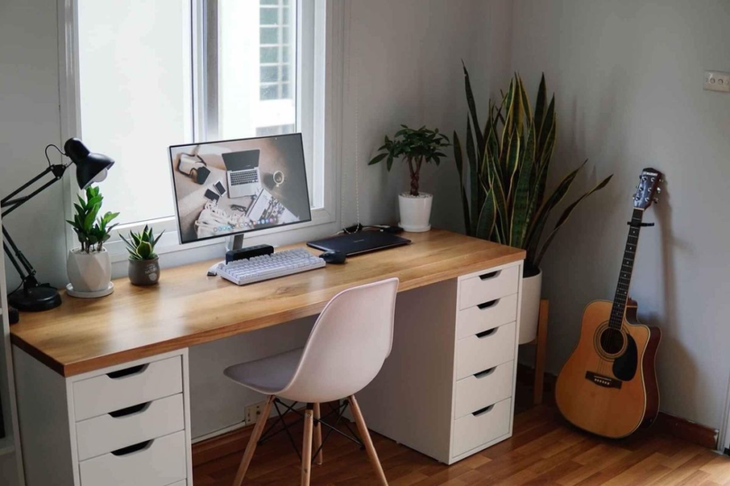 Setup bàn làm việc tối giản với kệ màn hình và cây xanh giúp tăng khả năng tập trung